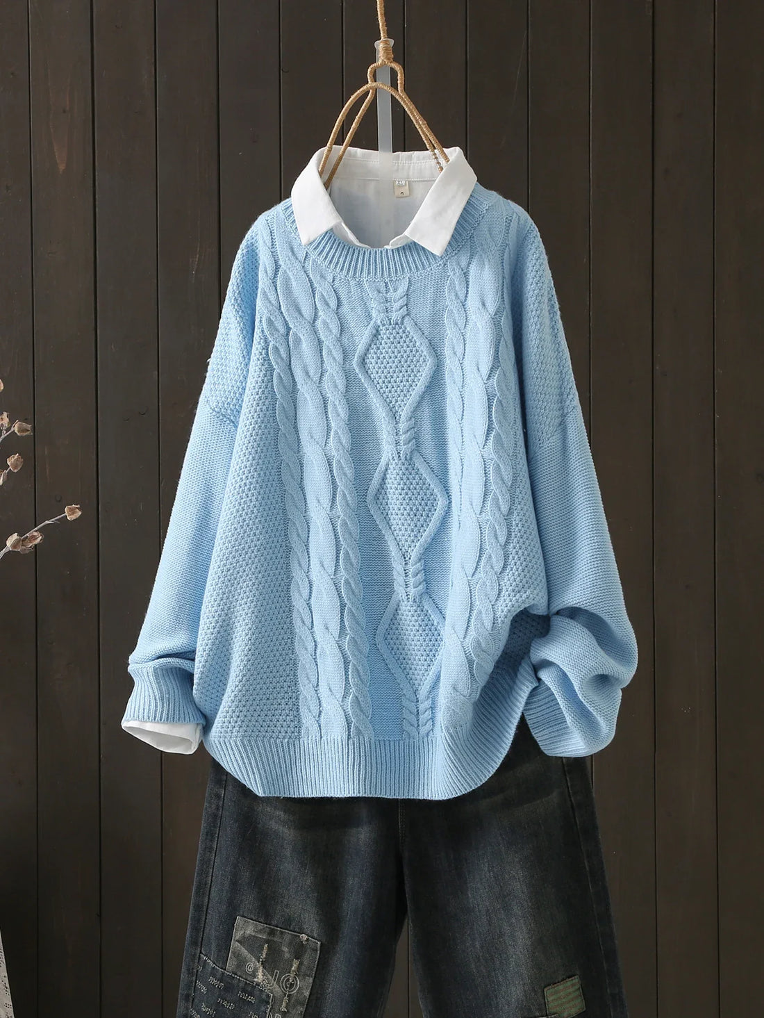 Light blue cable-knit crew neck sweater styled over a white collared shirt